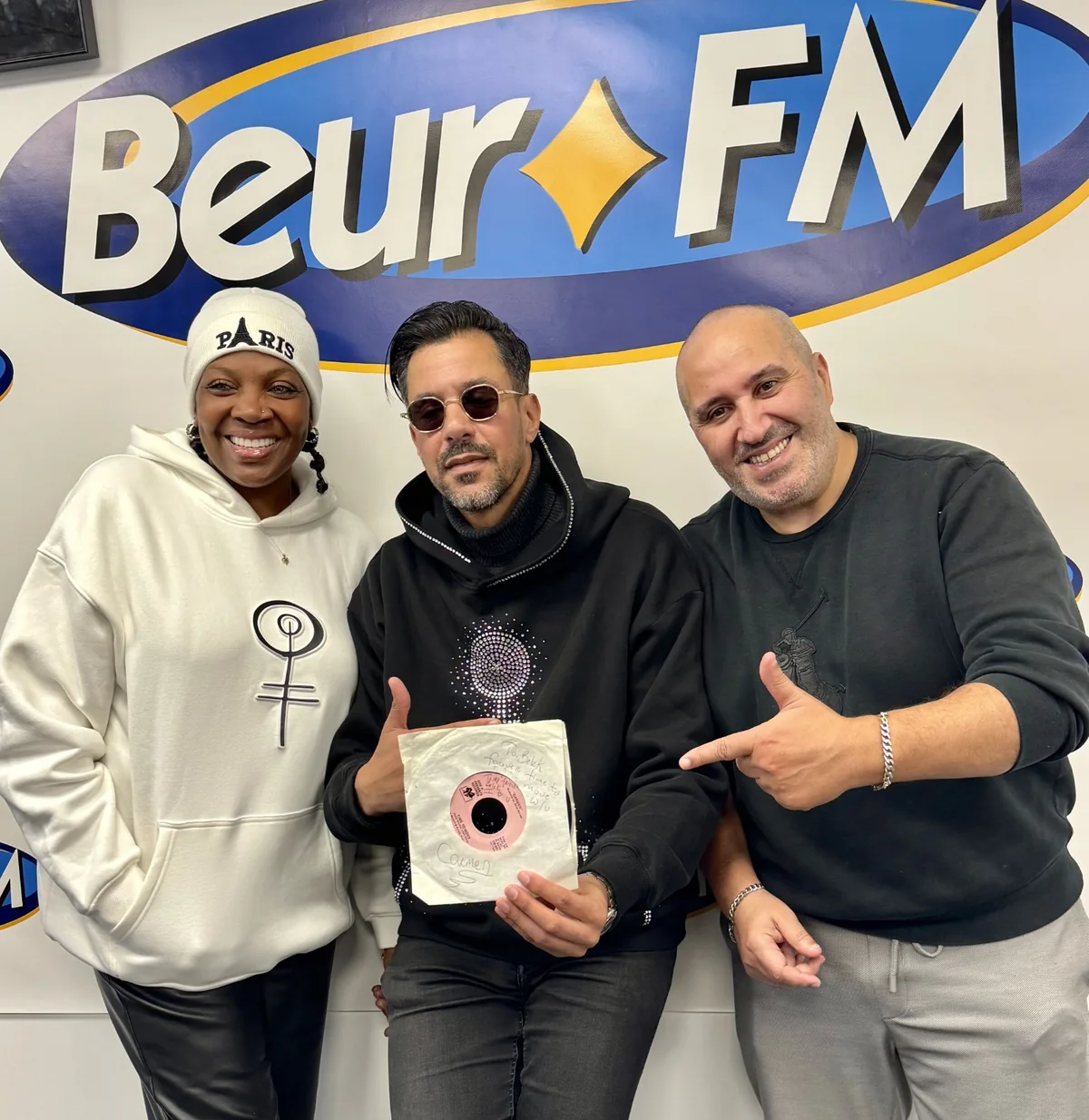 Carmen Clayton et deux invités dans les studios de Beur FM avec un disque vinyle